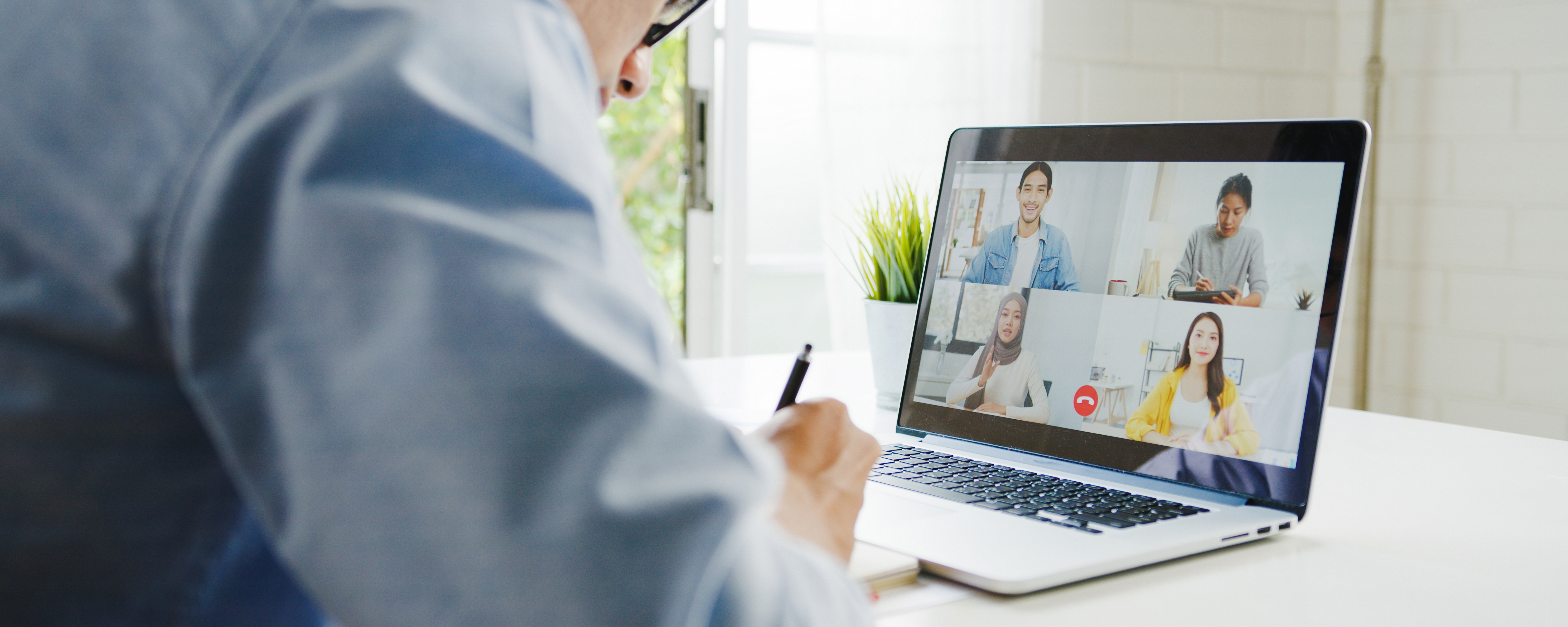 young-asia-businessman-using-laptop-talk-to-colleagues-about-plan-in-video-call-meeting-while-work-from-home-at-living-room-self-isolation-social-distancing-quarantine-for-corona-virus-prevention-jpg